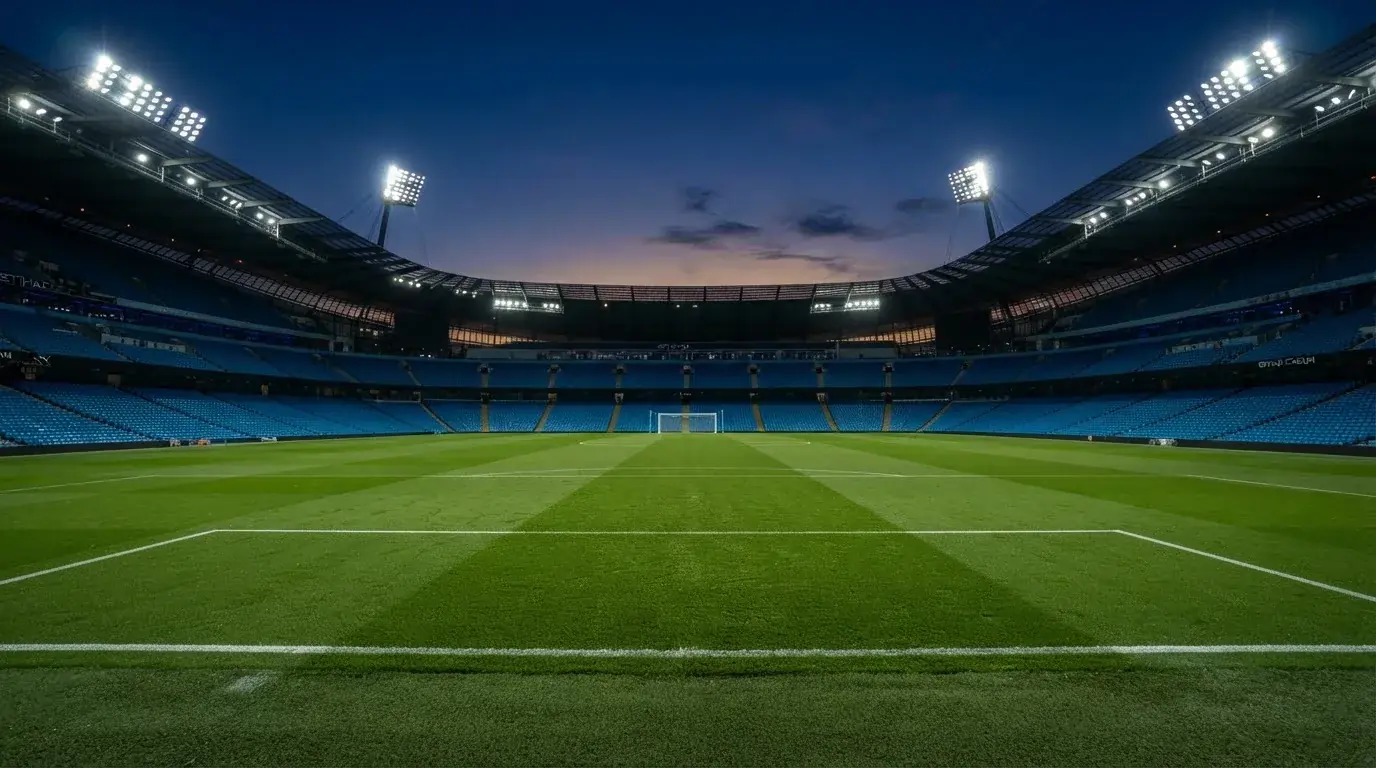 Een leeg voetbalstadion met lichtmasten bij schemering