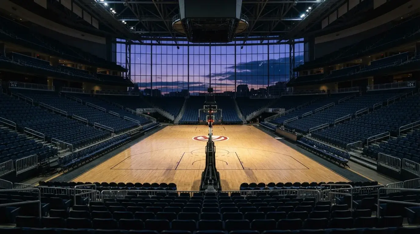 Een leeg voetbalstadion met lichtmasten bij schemering